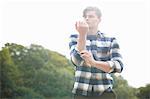 Portrait of man wearing plaid shirt rolling up sleeves