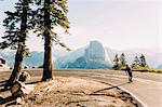 Skateboarder travelling on mountain road, Yosemite, California, USA