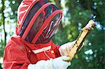 Beekeeper looking at hive frame