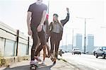 Skateboarders walking and skateboarding together on street, Budapest, Hungary