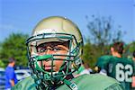 Portrait teenage male American football player wearing helmet at playing field