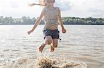 Girl jumping and splashing in river