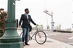 Young man walking outdoors with bicycle