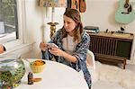 Woman sitting at dining table looking at smartphone