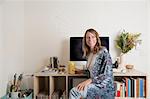 Woman sitting at desk looking away smiling