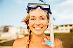 Portrait of woman wearing snorkel looking at camera smiling