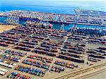 Aerial view of the container port at San Pedro in Los Angeles, with ships docked and containers awaiting loading. A commercial freight dockyard.