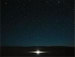 Glowing bright light on playa, night sky and Milky Way above, Black Rock Desert, Nevada