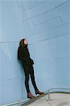 Portrait of thirteen year old teenage girl, standing against modern building