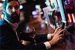 Businessman using digital tablet with wine glass on counter