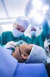 Surgeon adjusting oxygen mask on patient mouth in operation theater
