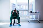 Tensed surgeon sitting on a chair