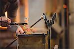 Glassblower shaping a molten glass