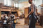 Glassblower shaping a molten glass