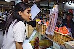 Thoughtful female staff standing at meat counter