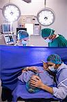 Team of doctors examining pregnant woman during delivery