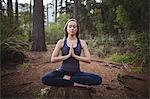 Woman performing yoga in forest