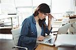 Thoughtful business executive using laptop