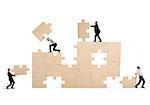 Team of businessmen collaborate and cooperate to build a puzzle