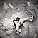 Businessman holding on to pieces of paper going to falling