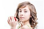 portrait on white of a girl holding a red apple she's about to bite and eat