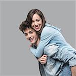 Smiling young couple having fun together and piggybacking