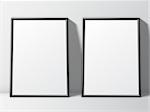 Two blank white posters in thin black frame standing on floor. Poster mock-up template