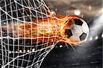 Professional soccer fireball leaves trails of flames and scores a goal on the net