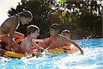 Children Having Fun On Inflatable In Outdoor Swimming Pool