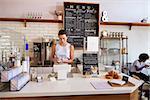 Waitress writing customerÕs order at counter of coffee shop