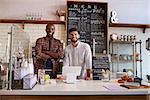 Business partners stand behind the counter at a coffee shop