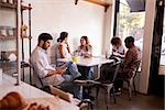 Five young adults hanging out at a coffee shop