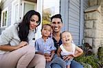 Portrait Of Family Sitting On Steps Outside Home