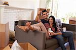 Couple On Sofa Holding Keys Taking A Break On Moving Day