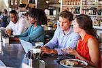 Group Enjoying Business Lunch At Delicatessen Counter