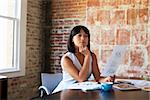 Businesswoman Making Notes On Document In Boardroom