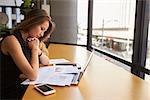 Businesswoman working reading document in office, side view