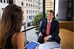 Businessman and woman using tablet at an office meeting