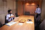 Businessman talks to colleague late in office, elevated view