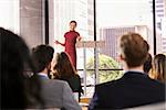 Young woman presenting business seminar gestures to audience