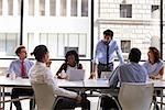 Manager standing to address colleagues at a business meeting