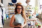 Female business owner holding tablet computer in clothes shop