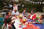 Multi generation black family at table for 4th July barbecue