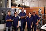 Portrait Of Engineers And Apprentices With CNC Machine