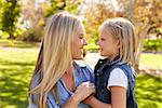 Blonde woman and her young daughter in a park side view