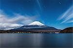 Night view of cloudy sky and Mount Fuji at night from Lake Yamanaka, Yamanashi Prefecture, Japan