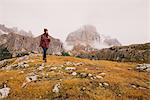 Hiker walking, Mount Lagazuoi in background, Dolomite Alps, South Tyrol, Italy
