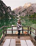 Woman leaning against wooden railings, Lago di Braies, Dolomite Alps, Val di Braies, South Tyrol, Italy