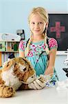 Portrait of girl pretending to be vet to toy tiger with intravenous drip