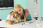 Portrait of girl pretending to be vet hugging toy tiger with intravenous drip